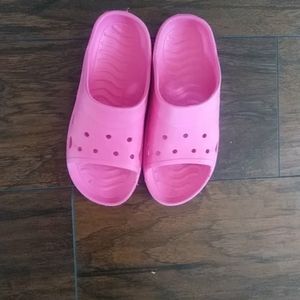 A pair of pink sandals over night bags